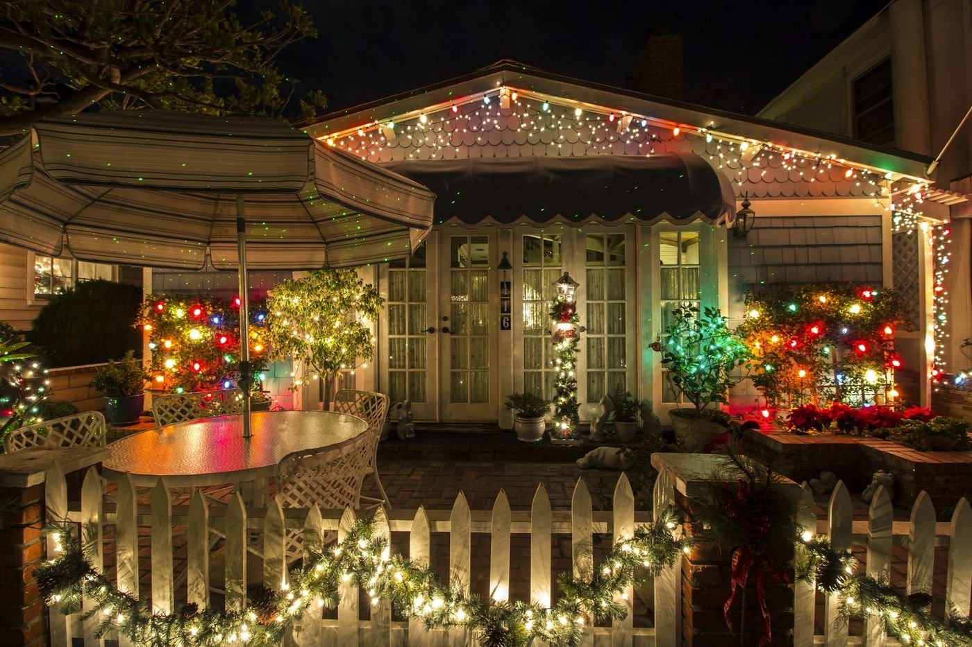 Cozy front porch decorated with warm holiday lights and garland at night